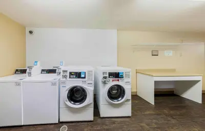 a laundry room with two washing machines and a table at Extended Stay America Suites - Los Angeles - Arcadia in Arcadia