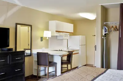 a small kitchen with a table and a refrigerator at Extended Stay America Suites - Los Angeles - Monrovia in Monrovia