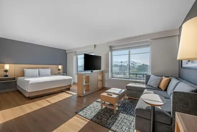 a hotel room with a bed and a couch at Hyatt Place Riverside Downtown in Riverside