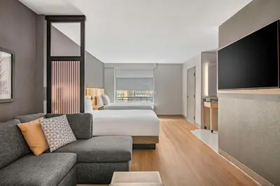 a hotel room with a couch and a bed at Hyatt Place Riverside Downtown in Riverside
