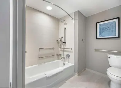 a bathroom with a white tub and a toilet at Hyatt Place Riverside Downtown in Riverside
