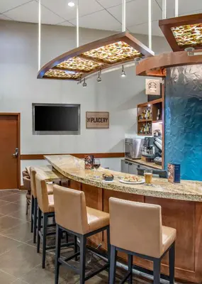 a bar in a restaurant with chairs and a counter at Hyatt Place Riverside Downtown in Riverside