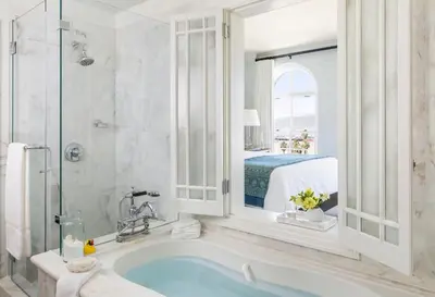 a bathroom with a tub and a window and a bed at Casa Del Mar in Los Angeles