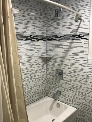 a bathroom with a bath tub and a sink at Executive Suites Inn in Westminster