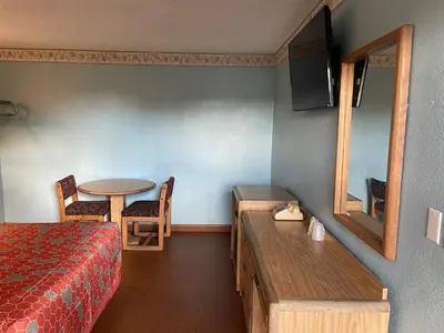 a hotel room with a bed and a table and a tableablish at Chester Inn Motel in Stanton