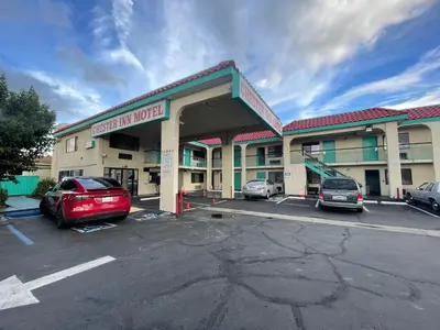 a hotel with cars parked in a parking lot at Chester Inn Motel in Stanton
