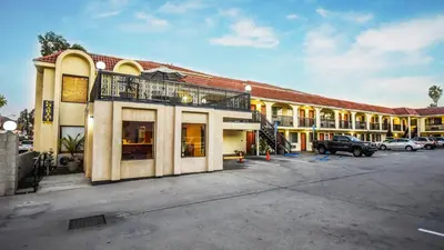 a large building with a truck parked in a parking lot at Chariot Inn Glendale - Pasadena in Glendale
