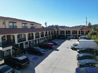 a large building with cars parked in a parking lot at Chariot Inn Glendale - Pasadena in Glendale