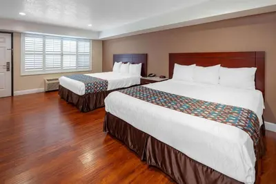 a hotel room with two beds and a window at Travelodge by Wyndham Harbor City in Harbor City