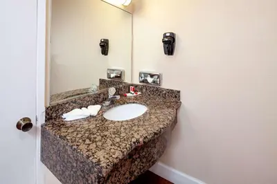 a bathroom with a sink and a mirror at Travelodge by Wyndham Harbor City in Harbor City