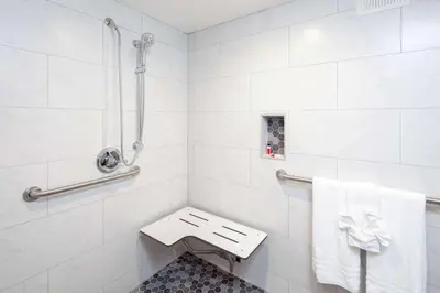a white bathroom with a toilet and a sink at Travelodge by Wyndham Harbor City in Harbor City