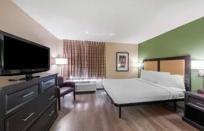a hotel room with a bed and a flat screen tv at Extended Stay America Suites - Orange County - Cypress in Cypress