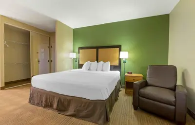 a hotel room with a bed and a chair at Extended Stay America Suites - Orange County - Cypress in Cypress