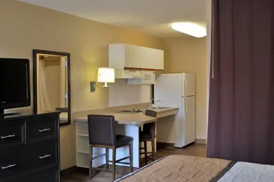 a small kitchen with a table and a refrigerator at Extended Stay America Suites - Orange County - Cypress in Cypress
