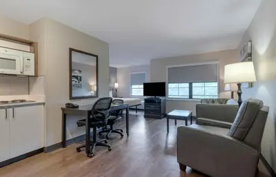 a living room with a kitchen and a desk with chairs at Extended Stay America Suites - Los Angeles - Burbank Airport in Burbank