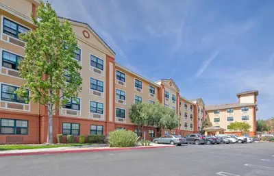 an apartment building with cars parked in a parking lot at Extended Stay America Suites - Los Angeles - Burbank Airport in Burbank
