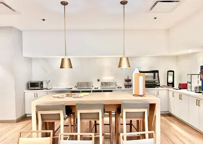 a kitchen with a large wooden table and chairs at Lincoln Hotel Monterey Park Los Angeles in Monterey Park