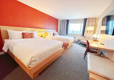 a hotel room with two beds and a desk at Lincoln Hotel Monterey Park Los Angeles in Monterey Park
