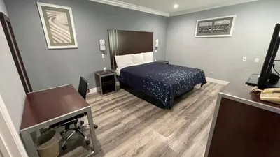 a small hotel room with a bed and a desk at Regency Motel in Brea