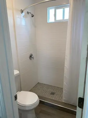 a bathroom with a toilet and a shower with a window at Regency Motel in Brea