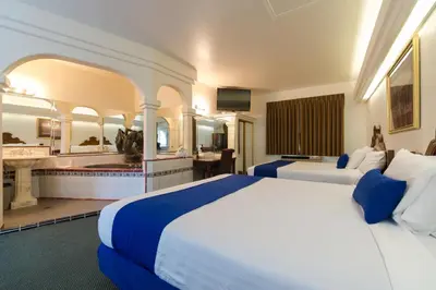 a hotel room with two beds and a bathroom at Colony Inn in North Hollywood