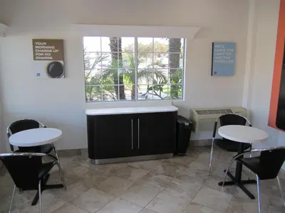 a waiting room with two tables and a window at Motel 6-Anaheim, CA in Anaheim