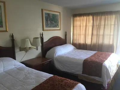 a hotel room with two beds and a window at Frontier Motel in Anaheim