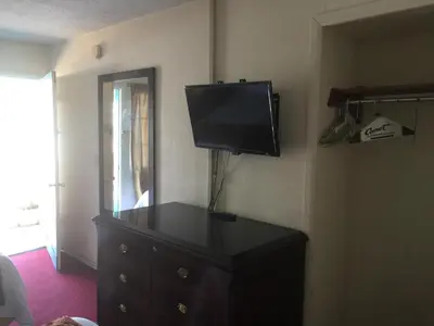 a tv on the corner of a room with a dresser at Frontier Motel in Anaheim