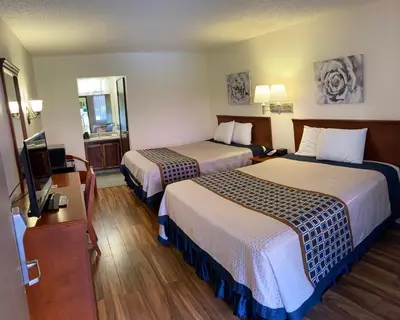 a hotel room with two beds and a flat screen tv at Vantage Point Inn - Woodland Hills in Woodland Hills
