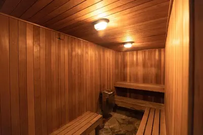 a wooden sauna with a bench and a toilet at Oxnard Inn Lancaster in Lancaster