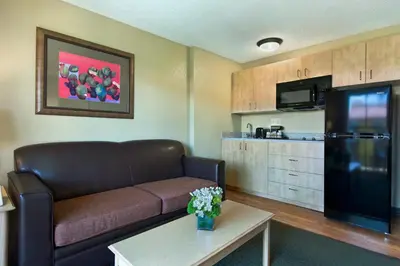 a living room with a couch and a kitchen at Oxnard Inn Lancaster in Lancaster