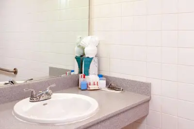 a bathroom counter with a sink and a mirror at Ramada Plaza by Wyndham West Hollywood Hotel & Suites in Los Angeles