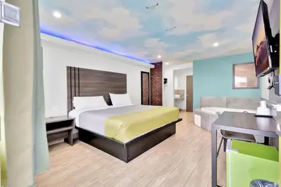 a hotel room with a bed and a desk at Exclusivo Inn and Suites in Lakewood