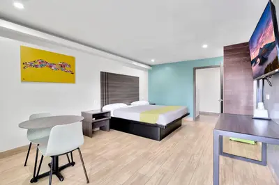 a hotel room with a bed and a desk and a table at Exclusivo Inn and Suites in Lakewood