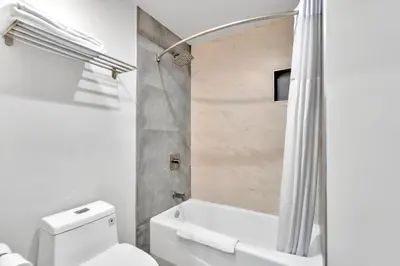 a bathroom with a white toilet and a shower at Exclusivo Inn and Suites in Lakewood