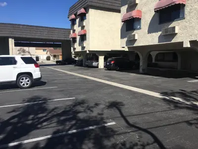 a white van parked in a parking lot next to a building at Grand Inn\u8ca1\u795e\u5ba2\u68e7 in Monterey Park