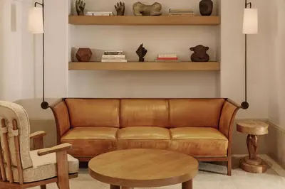 a living room with a brown couch and a chair at The Maybourne Beverly Hills, Maybourne in Los Angeles