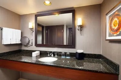 a bathroom with a sink and a large mirror at Sheraton Fairplex Suites & Conference Center in Pomona