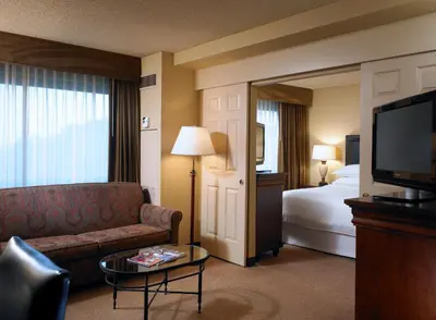 a hotel room with a couch and a bed and a television at Sheraton Fairplex Suites & Conference Center in Pomona