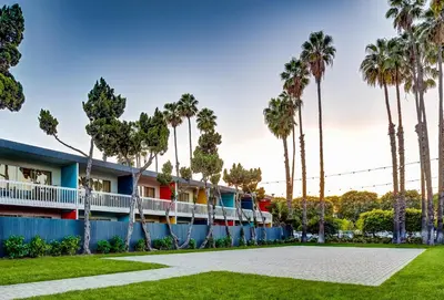 a building with palm trees in front of it at Anaheim Hotel in Anaheim
