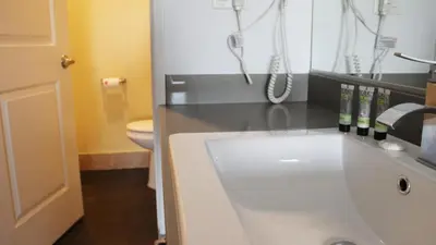 a bathroom with a sink and a phone at Hometel Suites in Los Angeles