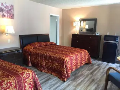 a hotel room with two beds and a television at King Lodge Motel in Monterey Park