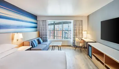 a hotel room with a bed and a flat screen tv at Hyatt Regency Orange County in Anaheim