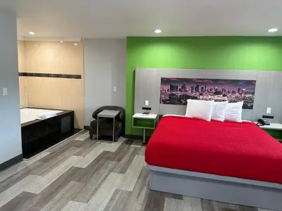 a hotel room with a red bed and a bathroom at Garden Inn San Gabriel in San Gabriel