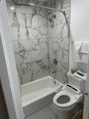 a bathroom with a toilet and a tub and a sink at Garden Inn San Gabriel in San Gabriel