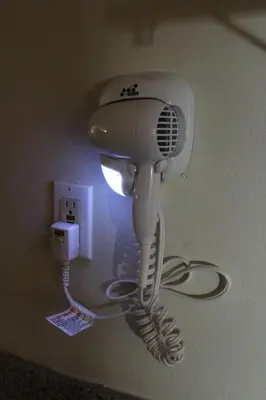 a white hair dryer hanging from a wall at Garden Inn San Gabriel in San Gabriel