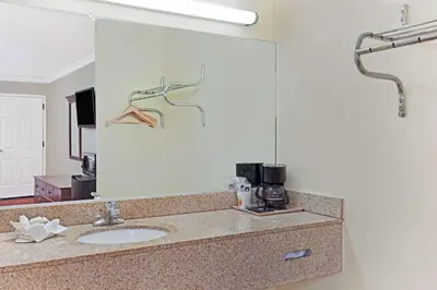 a bathroom with a sink and a large mirror at Super 8 by Wyndham North Hollywood in North Hollywood