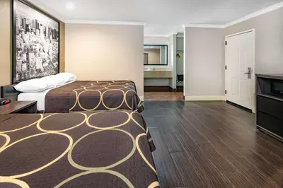a hotel room with a bed and a living room at Super 8 by Wyndham North Hollywood in North Hollywood
