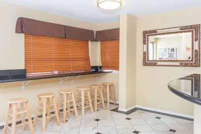 a bar with stools in a room with a mirror at Super 8 by Wyndham Azusa in Azusa
