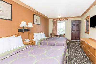 a hotel room with two beds and a flat screen tv at Super 8 by Wyndham Azusa in Azusa
